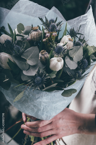 Florist at work on arragment flower bouquet on a wooden table photo