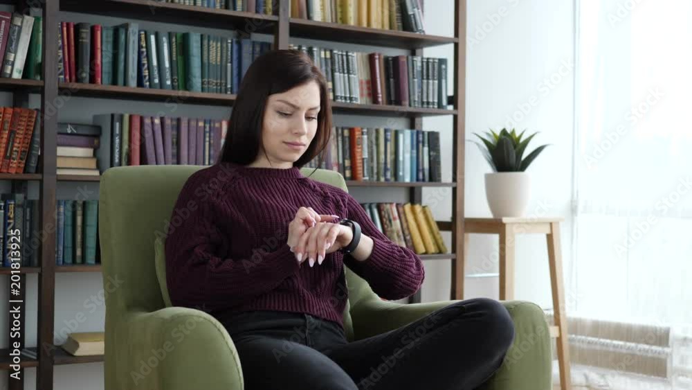 Woman Using Smartwatch while Sitting on Sofa Woman Using Smartwatch while Sitting on Sofa