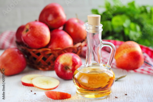 Apple vinegar. Bottle of apple vinegar on wooden background.