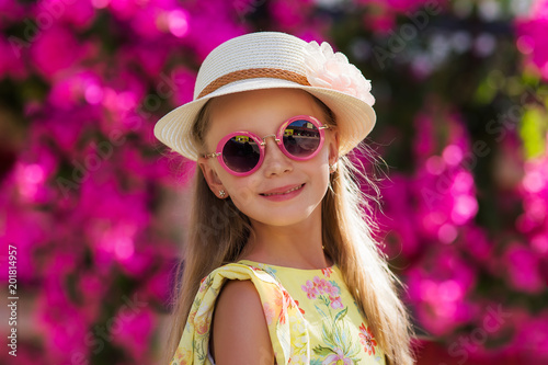 Young cute pretty blonde model girl portrait. Beautiful happy girl enjoying flowers in spring blooming lilac garden.