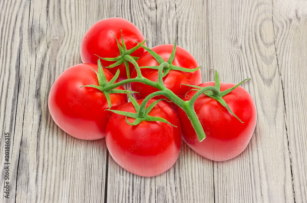 Branch of the red tomatoes on old wooden surface Branch of the red tomatoes on old wooden surface