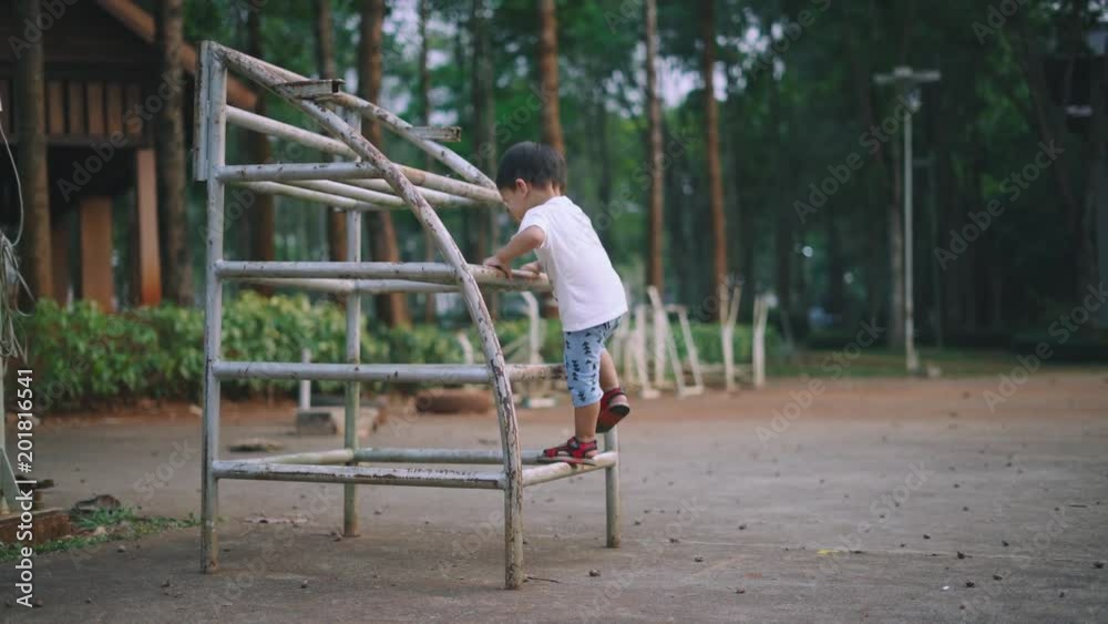 Asian boy about 2 year and 3 months climbing and having fun with rusty steel bar for muscle development Asian boy about 2 year and 3 months climbing and having fun with rusty steel bar for muscle development