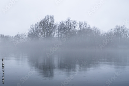 Dramatic background of foggy weather at the lake