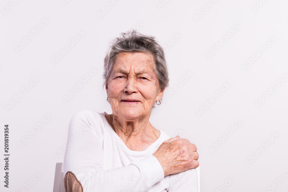 Studio portrait of a senior woman in pain. Studio portrait of a senior woman in pain.