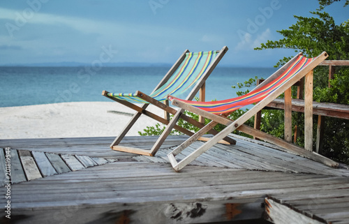 canvas bed at wood floor and beach in blue sky