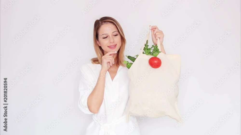 woman in white clothes showing bag with different vegetables woman in white clothes showing bag with different vegetables
