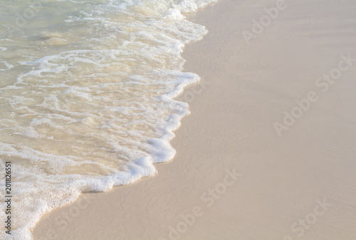 Sea wave and sand beach photo for background. Sunny beach sand with sea wave.
