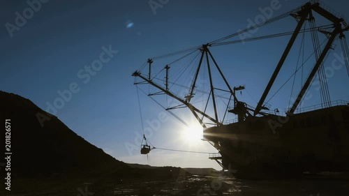 Dragline excavator loads ore. This area has been mined for buaxite, aluminum and other minerals. Open-cast. Operating mine.
