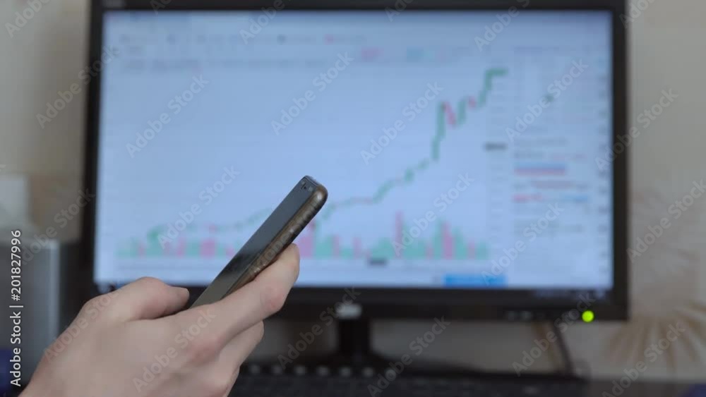 Man with a phone in his hands on the background of stock exchanges. Man with a phone in his hands on the background of stock exchanges.