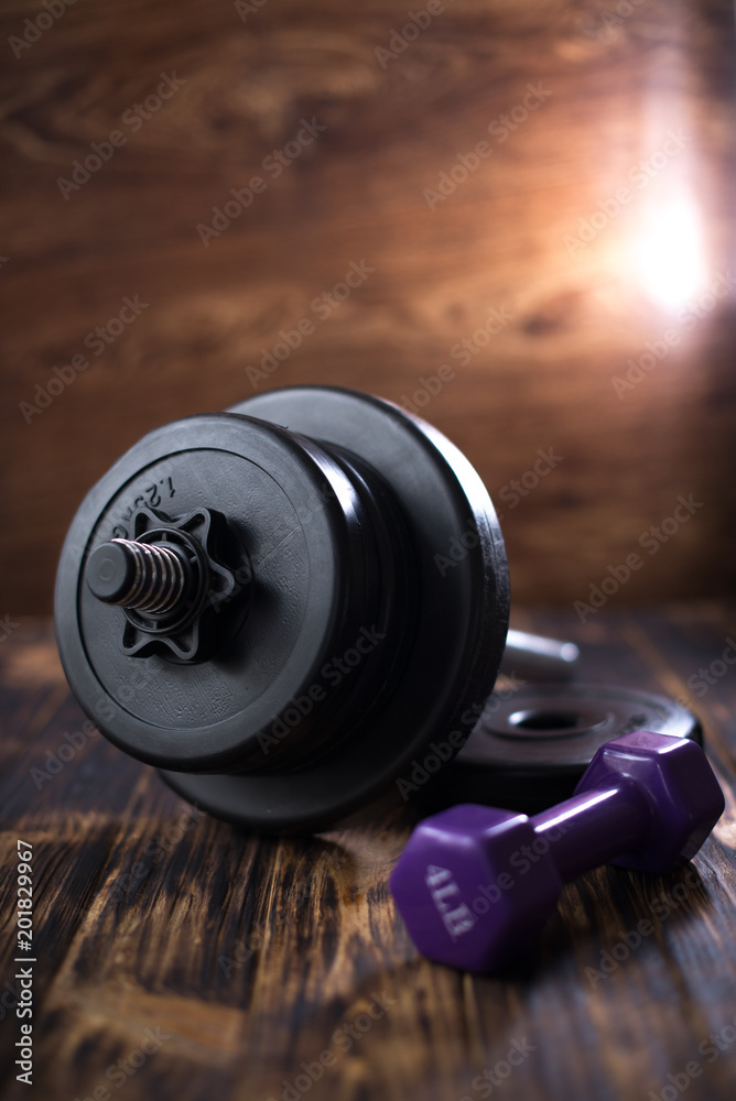 Dumbbells on a wooden dark background. Concept of playing sports Dumbbells on a wooden dark background. Concept of playing sports