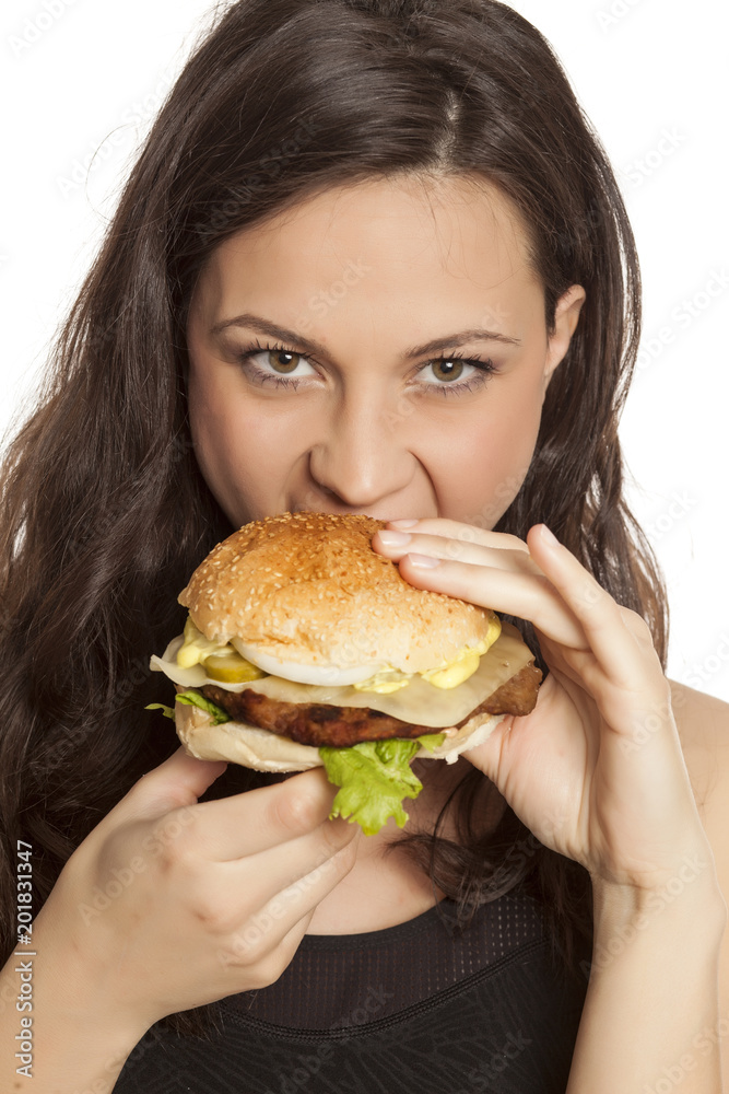 young beautiful greedy woman eating a hamburger on white background young beautiful greedy woman eating a hamburger on white background