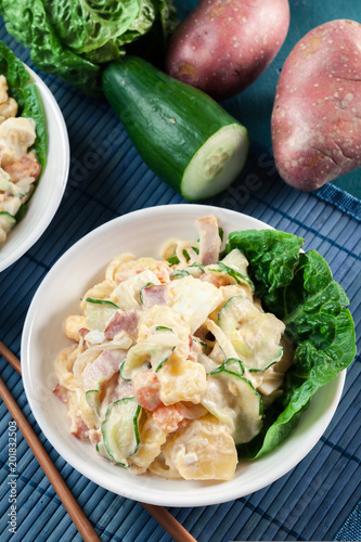 Cuadro en lienzo Delicious potato salad with ham, egg and cucumber