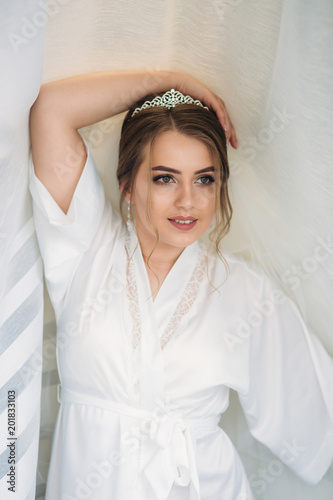 Portrait of the bride in a negligee under the white curtain
