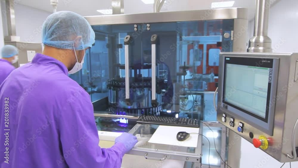 Operator control pharmaceutical manufacturing equipment. Factory worker ...