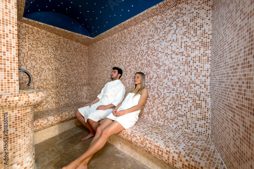 Young couple relaxing inside spa sauna turkish bath - Two lovers enjoying vacation in luxury resort hotel