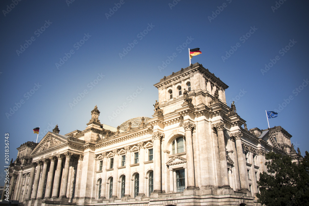 German parliament building reichstag in berlin with german flags on a sunny day