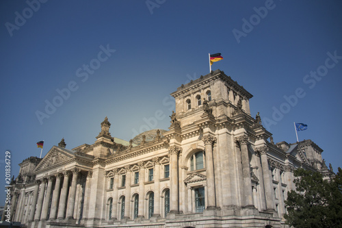 German parliament building reichstag in berlin with german flags on a sunny day