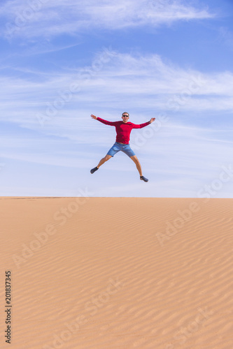 Tourist jumps on dune of Wadi Araba desert, Jordan