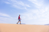 Tourist walks on dune of Wadi Araba desert, Jordan