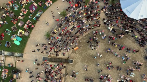 Top view of people sitting on a late summer evening open air event at the Donau shore in Ingolstadt, Germany (next to Klenzepark). Camera on rotation and lift up. photo