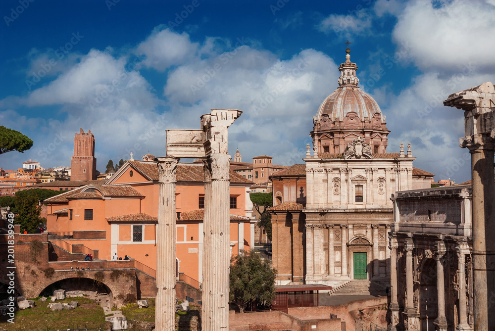 Roman Forum ruins of temples, columns arch and baroque church in the historic center of Rome