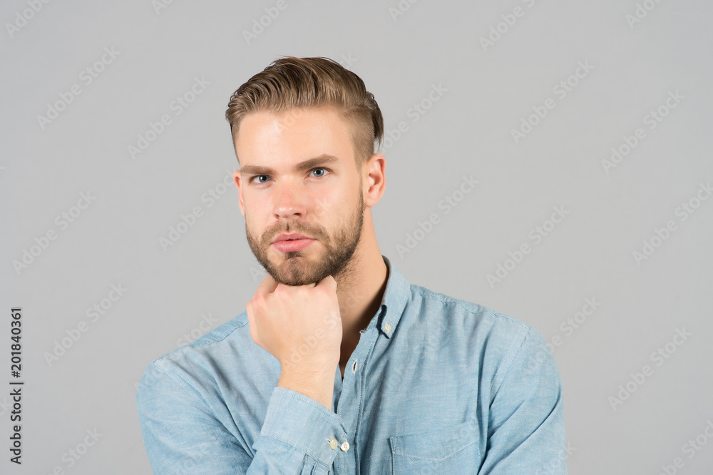 Guy with stylish hair touch beard with hand. Bearded man with healthy young skin. Macho with unshaven face and mustache. Beard grooming and hair care in barbershop. Skincare and mens beauty concept Guy with stylish hair touch beard with hand. Bearded man with healthy young skin. Macho with unshaven face and mustache. Beard grooming and hair care in barbershop. Skincare and mens beauty concept