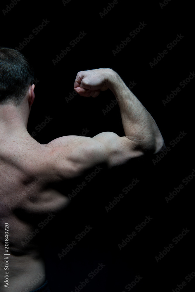 Man athlete with half torso, back view. Sportsman flex arm muscles. Bodybuilder show biceps and triceps. Workout and training activity in gym. Sport power and bodycare concept Man athlete with half torso, back view. Sportsman flex arm muscles. Bodybuilder show biceps and triceps. Workout and training activity in gym. Sport power and bodycare concept