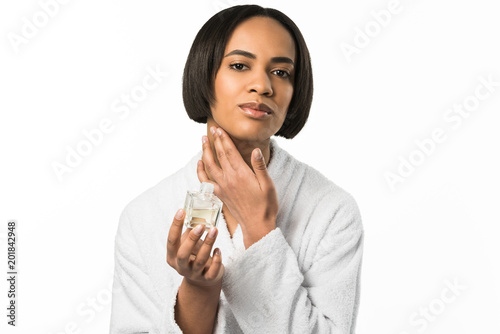 attractive african american woman applying perfume on neck, isolated on white
