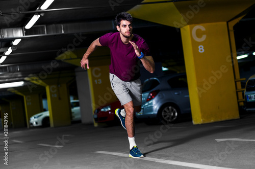 Portrait of young male athlete running in the underground car parking. © Zoran Zeremski