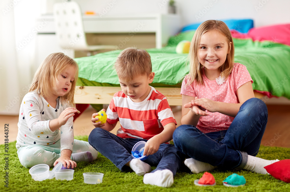 childhood, leisure and people concept - group of kids with modelling clay or slimes at home childhood, leisure and people concept - group of kids with modelling clay or slimes at home