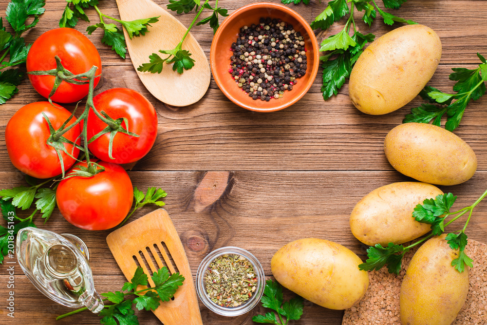 Fresh vegetables, greens and spices on a wooden background. Space for the inscription. Top View