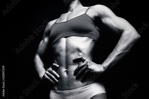 Fitness woman posing against a black background