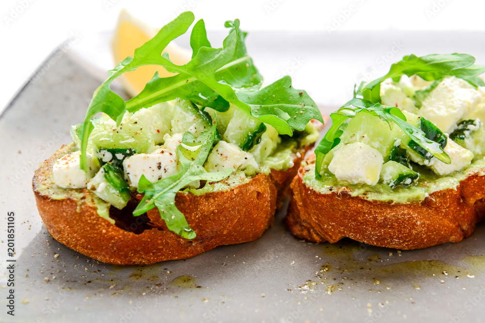 Tasty savory Italian appetizers, or bruschetta, on slices of toasted baguette garnished with basil Tasty savory Italian appetizers, or bruschetta, on slices of toasted baguette garnished with basil