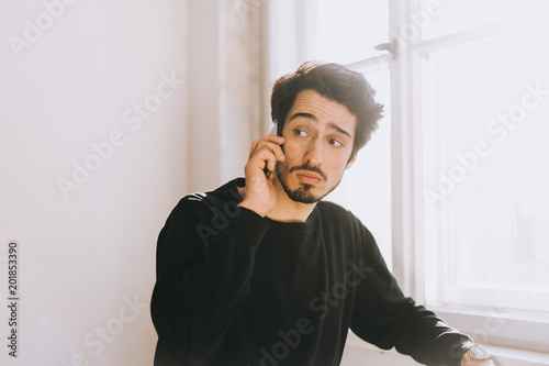 Junger Mann telefoniert mit besorgtem Blick