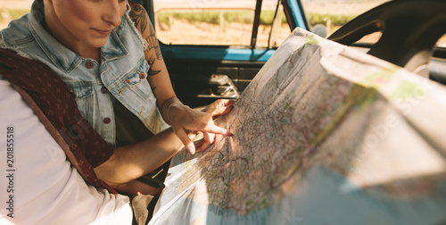 Young travellers on a road trip looking at map