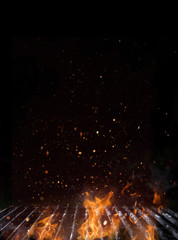 Empty flaming charcoal grill with open fire.