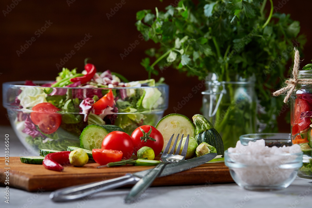 Fresh vegetable salad and ripe veggies on cutting board over white background, close up, selective focus Fresh vegetable salad and ripe veggies on cutting board over white background, close up, selective focus