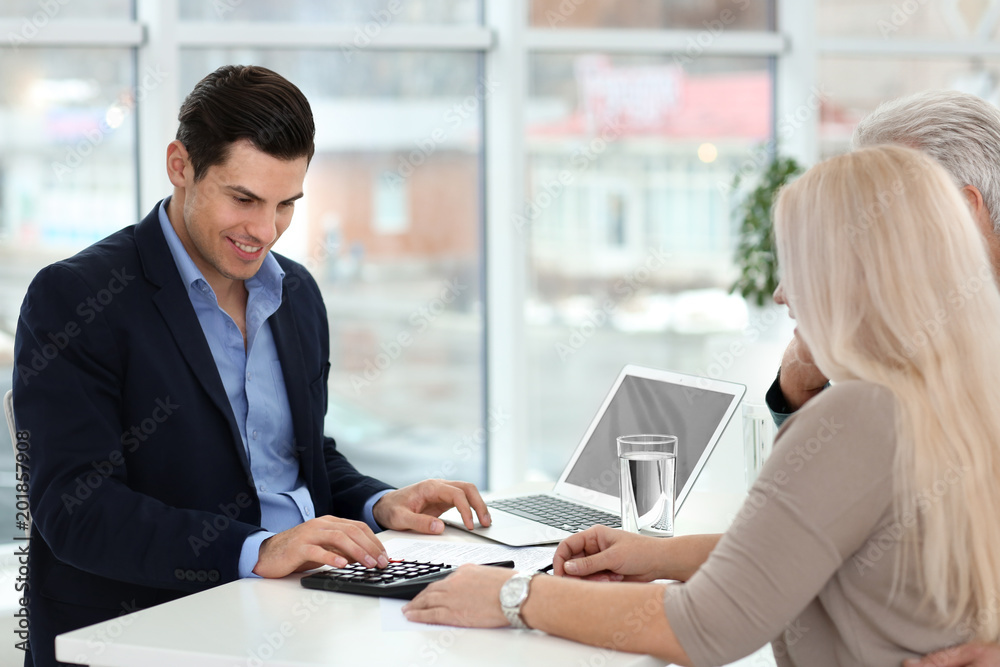 Mature couple discussing pension with consultant in office Mature couple discussing pension with consultant in office