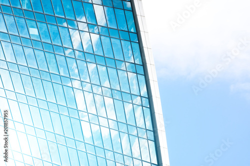 Reflection of sky and clouds in glass windows of financial skyscrapers.
