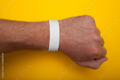 White wristband, bracelet mockup for event on yellow background.