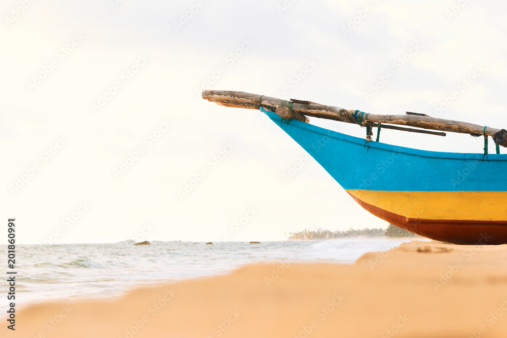 Close-up Sri-Lanka fishing boat on the ocean Narigama beach. Traditional blue-yellow wooden painted ship.