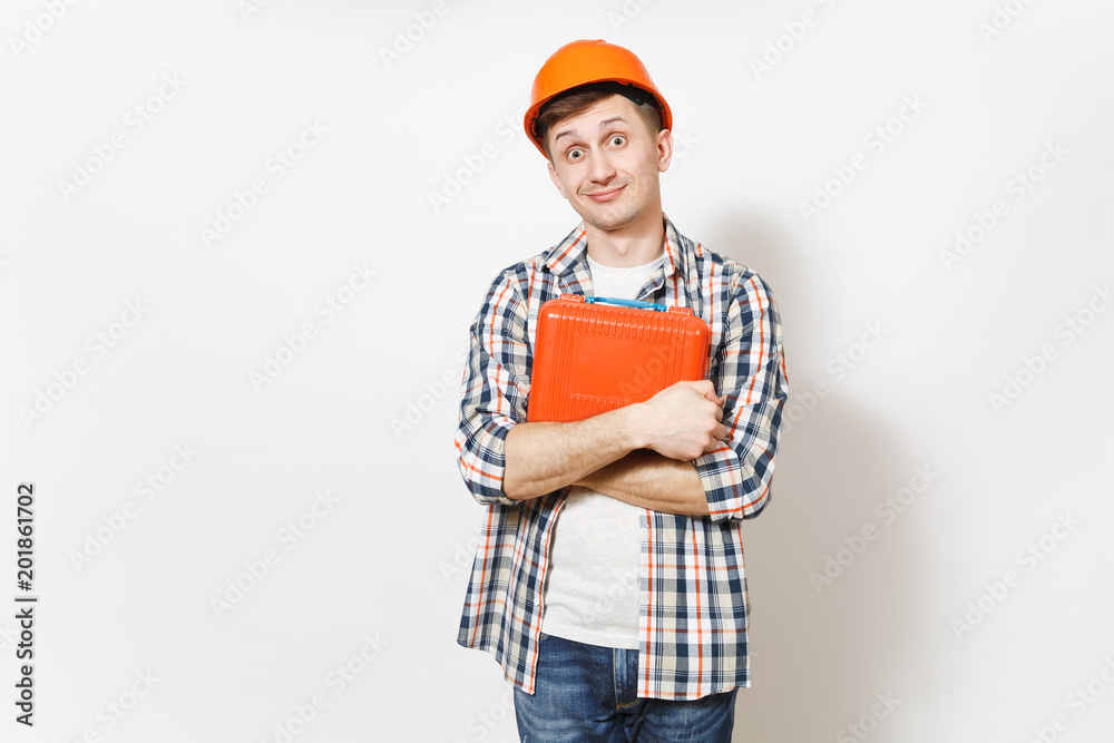 Young fun handsome man in protective orange hardhat holding case with instruments or toolbox isolated on white background. Instruments, tools for renovation apartment room. Repair home concept. Young fun handsome man in protective orange hardhat holding case with instruments or toolbox isolated on white background. Instruments, tools for renovation apartment room. Repair home concept.