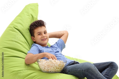 Boy with a bowl of popcorn sitting on a beanbag