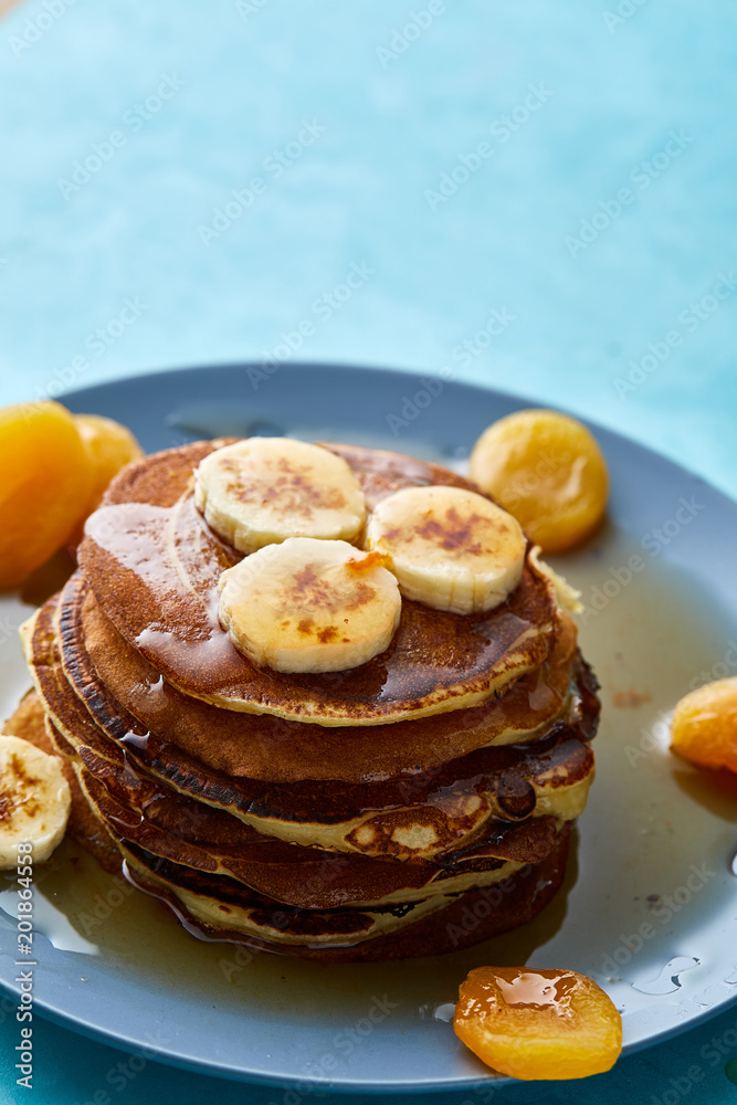 Pile of homemade pancakes with honey and walnuts on rustic wooden background, selective focus Pile of homemade pancakes with honey and walnuts on rustic wooden background, selective focus