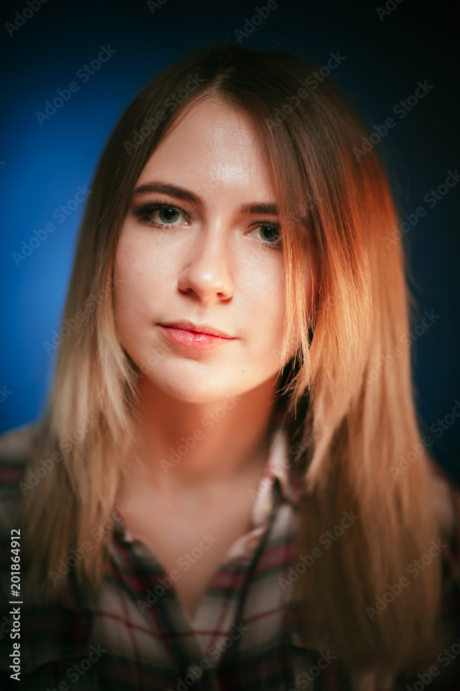 portrait smiling girl on blue background in studio