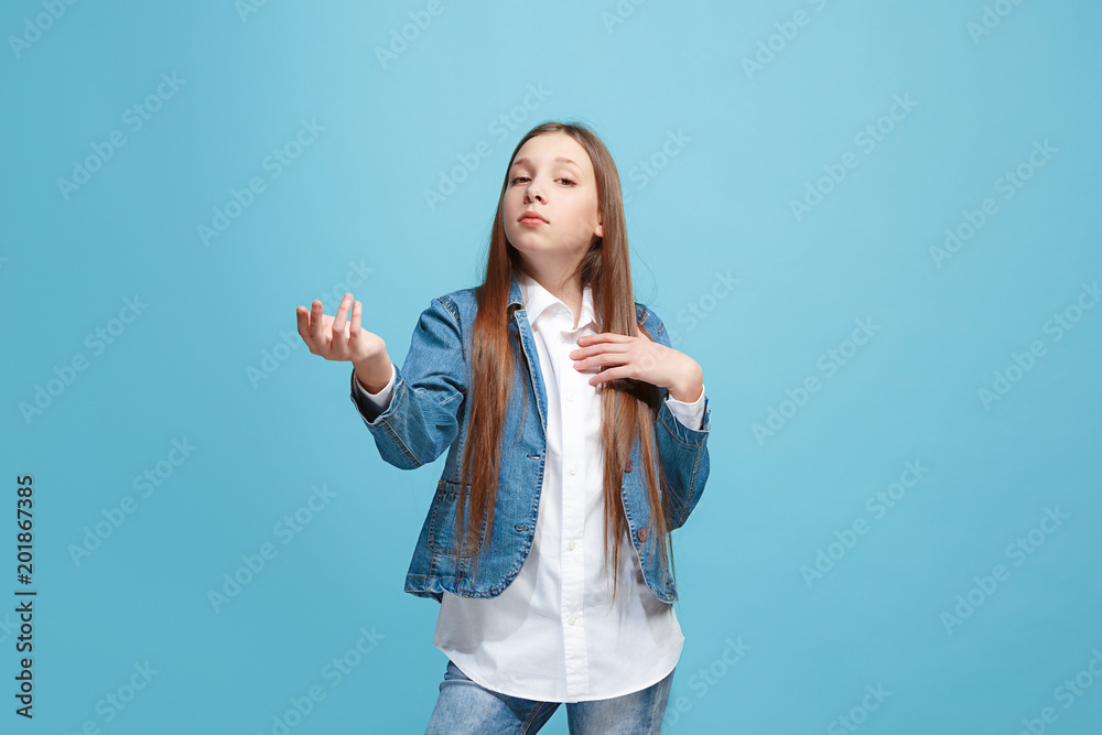 Beautiful female half-length portrait on blue studio backgroud. The young emotional teen girl Beautiful female half-length portrait on blue studio backgroud. The young emotional teen girl