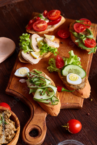 Breakfast sandwich with homemade paste, vegetables and fresh greens, shallow depth of field