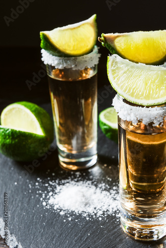 three glasses of tequila and pieces of lime