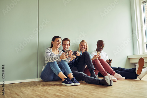 Young coworkers sitting on an office floor during a break
