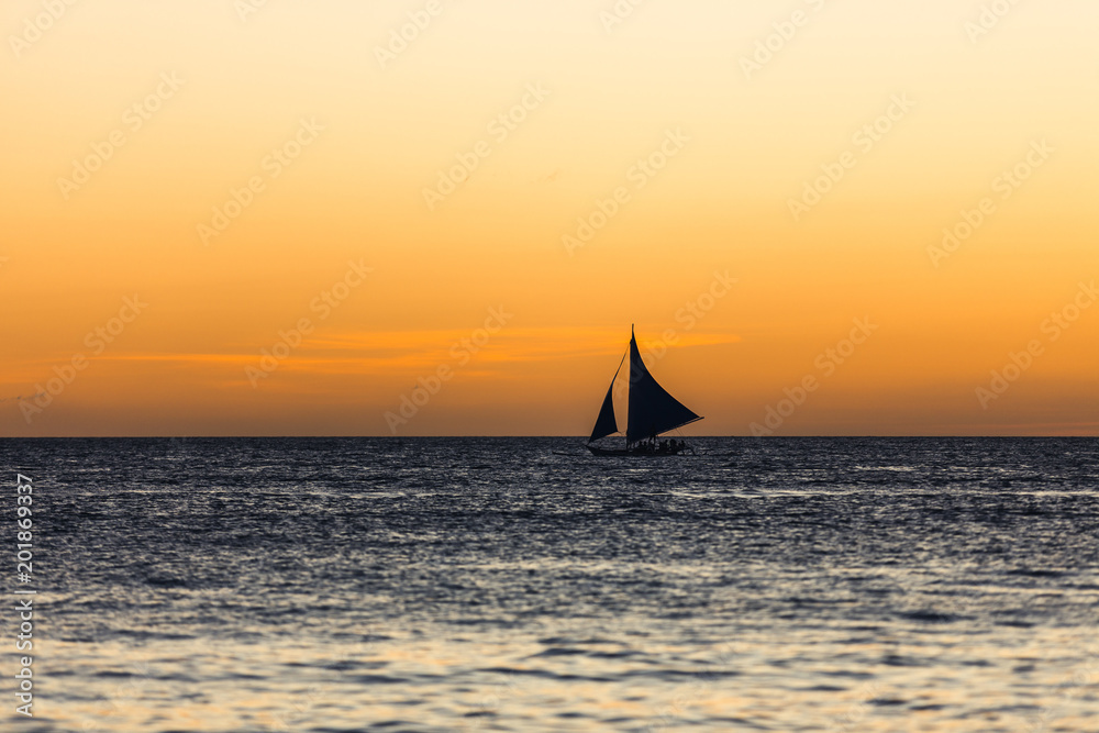 One outrigger sailboat on the horizon